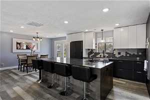 Kitchen featuring a center island, pendant lighting, white cabinetry, and hardwood / wood-style flooring