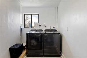 Laundry room with a textured ceiling and independent washer and dryer