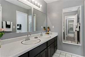 Bathroom featuring dual sinks, tile floors, and oversized vanity