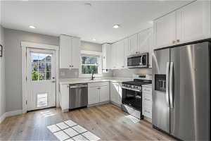 Kitchen with appliances with stainless steel finishes,  and white cabinetry