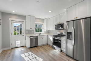 Kitchen with appliances with stainless steel finishes,  and white cabinetry