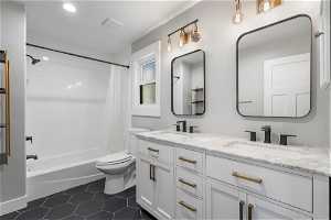Full bathroom with tile flooring, double vanity, shower / bath combination