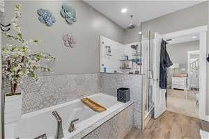 Bathroom featuring hardwood / wood-style flooring and separate shower and tub