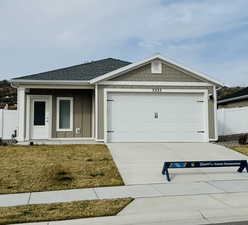 Ranch-style home with driveway, fence, a garage, and roof with shingles