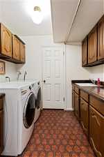 Laundry room with storage room and sink
