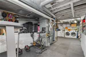 Basement featuring water heater, furnaces, and washer and dryer as well as lots of storage and gym area