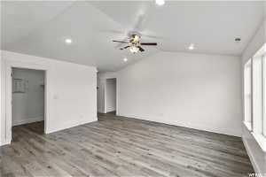 Unfurnished room featuring lofted ceiling, ceiling fan, and hardwood / wood-style flooring