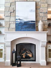 Room details featuring a stone fireplace and hardwood / wood-style flooring