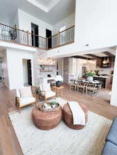 Living room featuring a towering ceiling, a chandelier, and light wood-type flooring