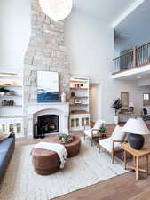 Living room featuring a high ceiling, hardwood / wood-style flooring, and a fireplace