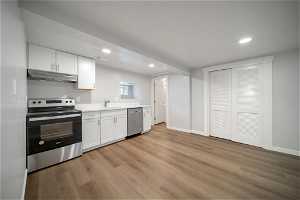 Full basement kitchen with range, range hood and dishwasher.