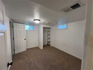 Basement with dark colored carpet