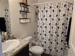 Full bathroom with vanity, toilet, and shower / bathtub combination with curtain