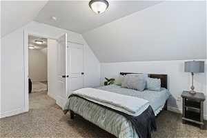 Bedroom featuring vaulted ceiling and carpet