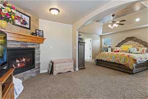 Bedroom featuring ceiling fan, a fireplace, and carpet floors