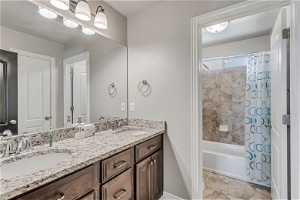 Bathroom featuring shower / tub combo with curtain, tile floors, and double sink vanity
