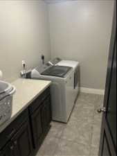 Washroom with cabinets, light tile flooring, washer and dryer, and electric dryer hookup