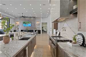Kitchen with ceiling fan, double oven range, wine cooler, sink, and light hardwood / wood-style flooring