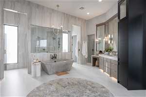 Bathroom with a healthy amount of sunlight, a notable chandelier, tile floors, and vanity with extensive cabinet space