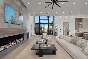 Living room featuring floor to ceiling windows, ceiling fan, light hardwood / wood-style floors, and a tile fireplace