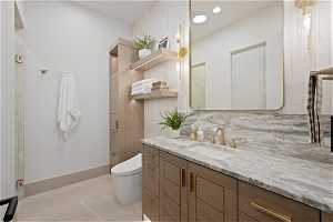 Bathroom featuring tile walls, backsplash, toilet, vanity, and tile floors
