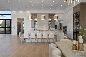 Kitchen featuring backsplash, a wealth of natural light, pendant lighting, and light wood-type flooring