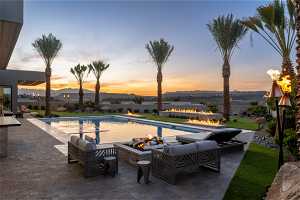 Pool at dusk featuring an outdoor living space, a mountain view, and a patio