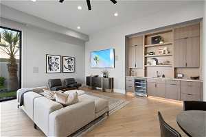 Living room with wine cooler, ceiling fan, sink, and light wood-type flooring