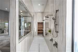 Bathroom featuring a shower, tile flooring, and tile walls