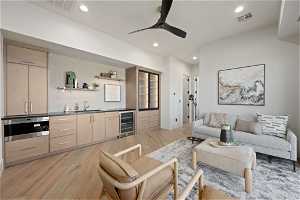 Living room with sink, ceiling fan, light hardwood / wood-style floors, and wine cooler