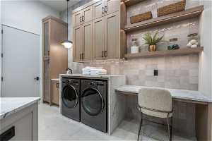 Laundry area featuring tile walls, cabinets, independent washer and dryer, and light tile flooring