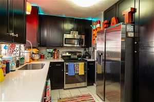 Kitchen featuring tasteful backsplash, appliances with stainless steel finishes, and light tile floors