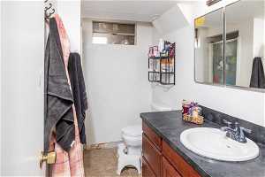 Bathroom featuring tile floors, oversized vanity, toilet, and a textured ceiling