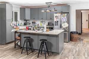 Kitchen with light stone countertops, tasteful backsplash, stainless steel appliances, and light hardwood / wood-style floors