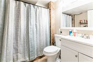 Bathroom basement featuring vanity, tile floors, and toilet
