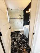Bathroom with tile flooring, vanity, toilet, and a shower with shower door