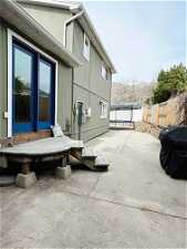 View of terrace featuring area for grilling, a wooden deck, and a trampoline
