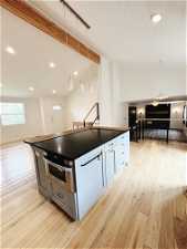 Kitchen featuring a kitchen island, oven, hanging light fixtures, and light wood-type flooring