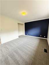 Unfurnished room featuring carpet flooring and crown molding