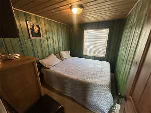 Bedroom featuring wood ceiling and wood walls