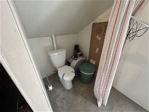 Bathroom featuring vaulted ceiling and toilet