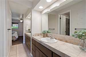 Bathroom featuring tile flooring, dual sinks, ceiling fan, and oversized vanity