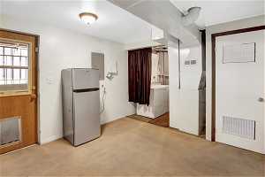 Interior space with light colored carpet and washing machine and clothes dryer