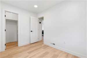 Unfurnished bedroom featuring light hardwood / wood-style floors and a closet