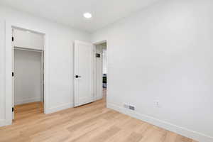 Unfurnished bedroom featuring light hardwood / wood-style floors and a closet