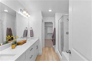 Bathroom featuring walk in shower, hardwood / wood-style floors, and dual vanity