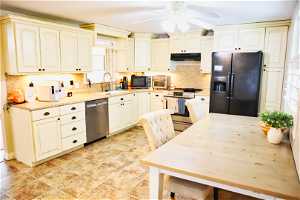 Kitchen with backsplash, ceiling fan, black appliances, and light tile flooring