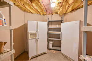 Basement with white fridge and white fridge with ice dispenser