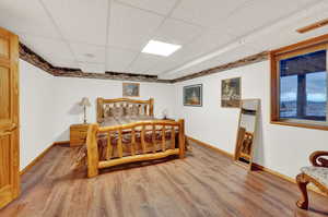 Bedroom featuring a paneled ceiling and hardwood / wood-style floors