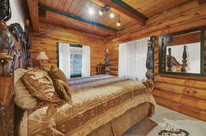 Bedroom featuring wooden ceiling, beam ceiling, and rustic walls